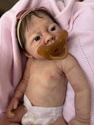 Senior woman with Alzheimer’s smiling while holding a lifelike reborn therapy doll in a nursing home setting